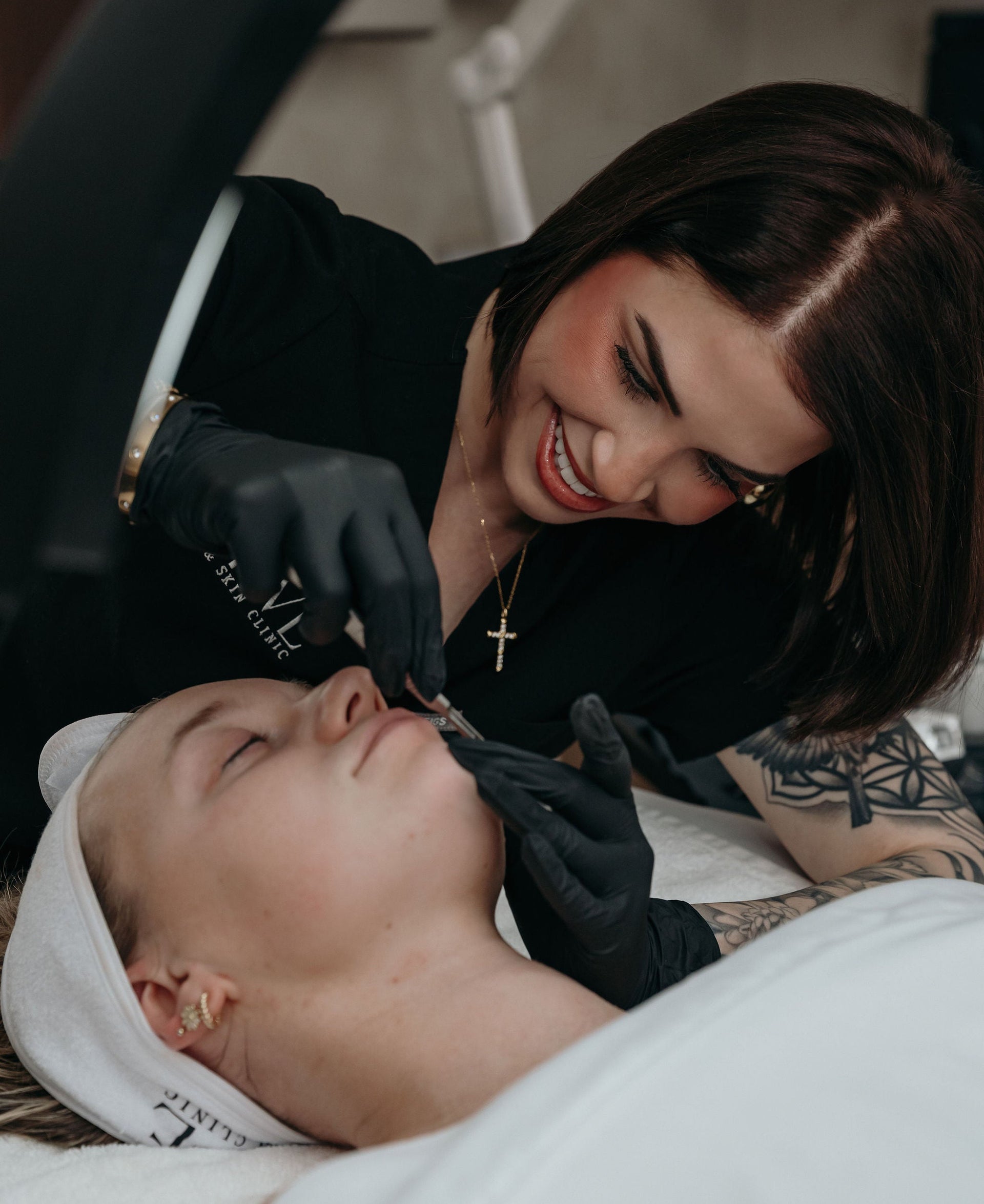 Professional esthetician working on a client's face with a hydrafacial machine.